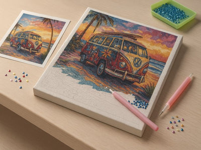 Cross-stitch kit with a Volkswagen van design on a wooden surface with pins and a pen.