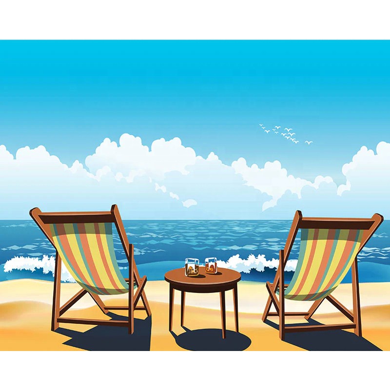 Two striped beach chairs and a small table with drinks on a sandy beach facing the ocean under a bright blue sky.