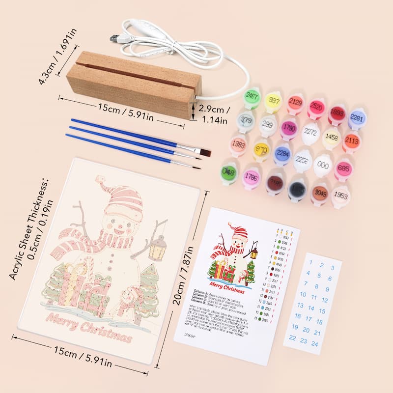 Christmas-themed DIY canvas painting kit with a wooden block, paint brushes, multiple small paint pots, an acrylic sheet with a snowman design, a Christmas calendar, and instruction cards, shown on a light beige background with product dimensions overlaid.