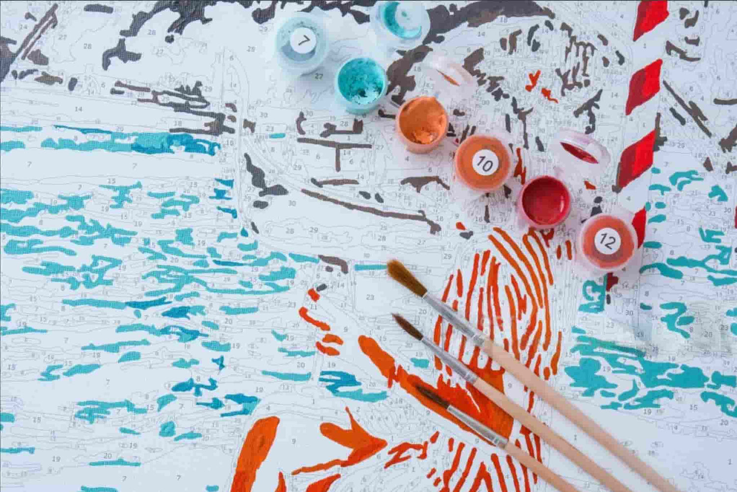 Artistic painting with colorful paint bottles and brushes on a textured surface.