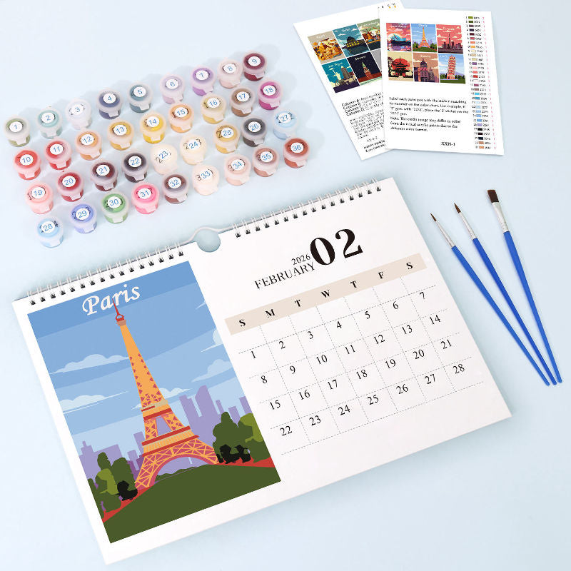 Calendar with Paris design, paint bottles, and brushes on a light blue background